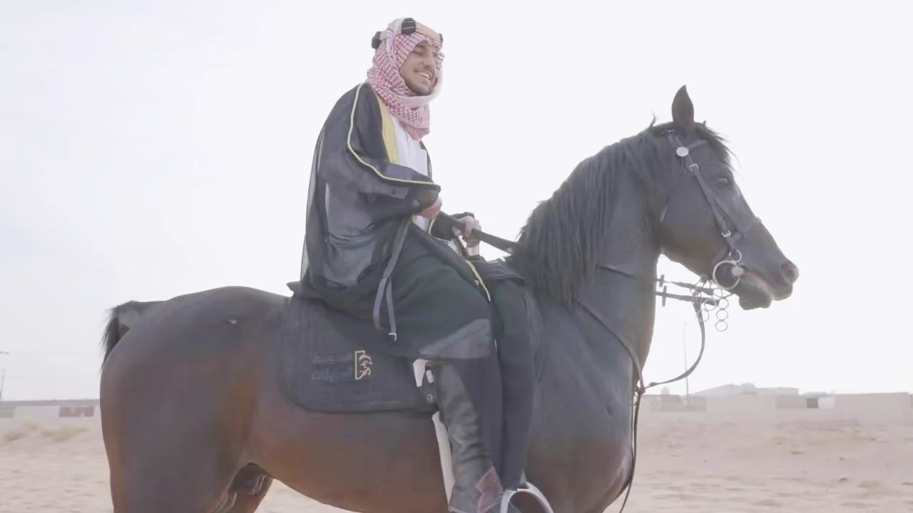Muhammad on horseback in the desert, wearing a bisht